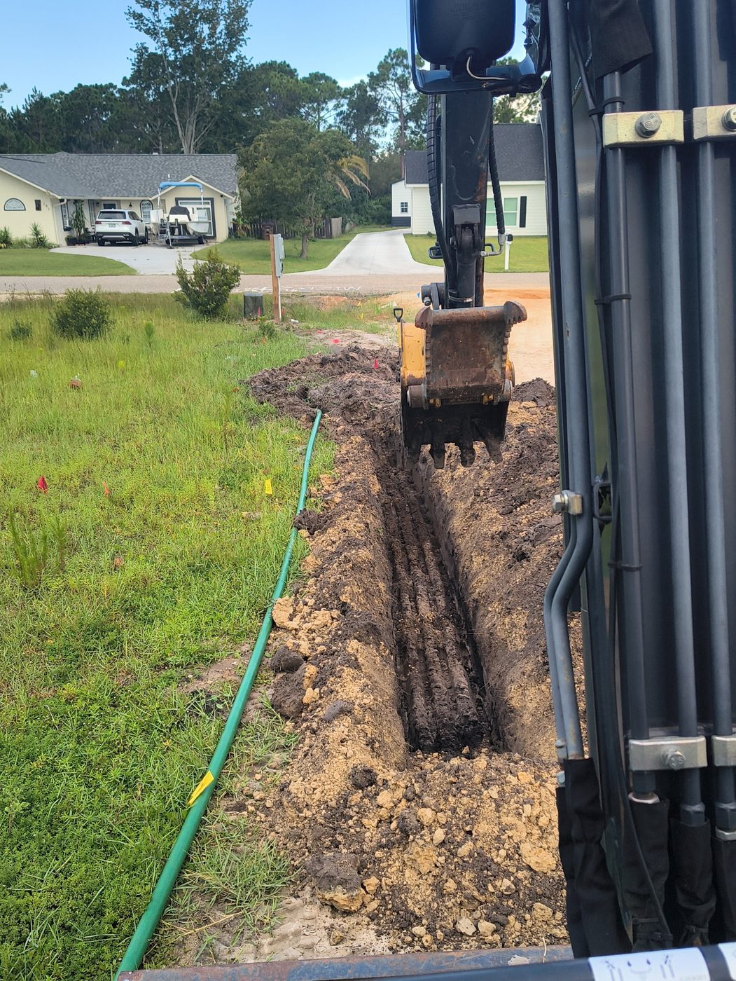 Excavator digging a trench for water and sewer line installation